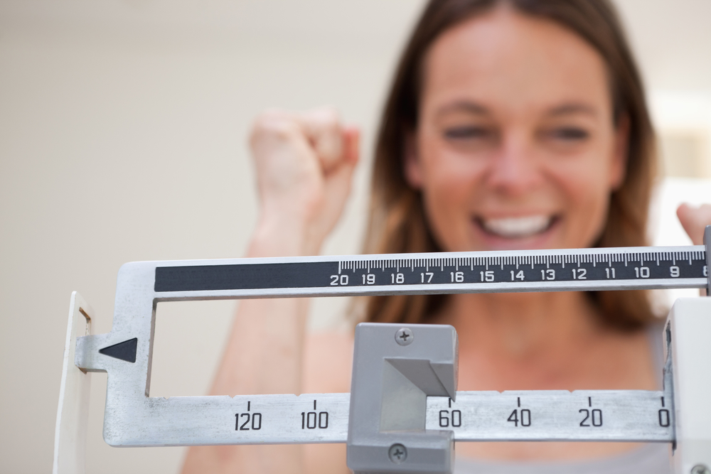weight loss shown on scale with happy patient